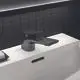 Waschtischarmatur in Magnetic Grey von Ideal Standard, montiert auf weißem Waschbecken, mit einem flachen Hebel und rechteckigem Auslauf. Hintergrund aus schwarzem Fliesenmuster.
